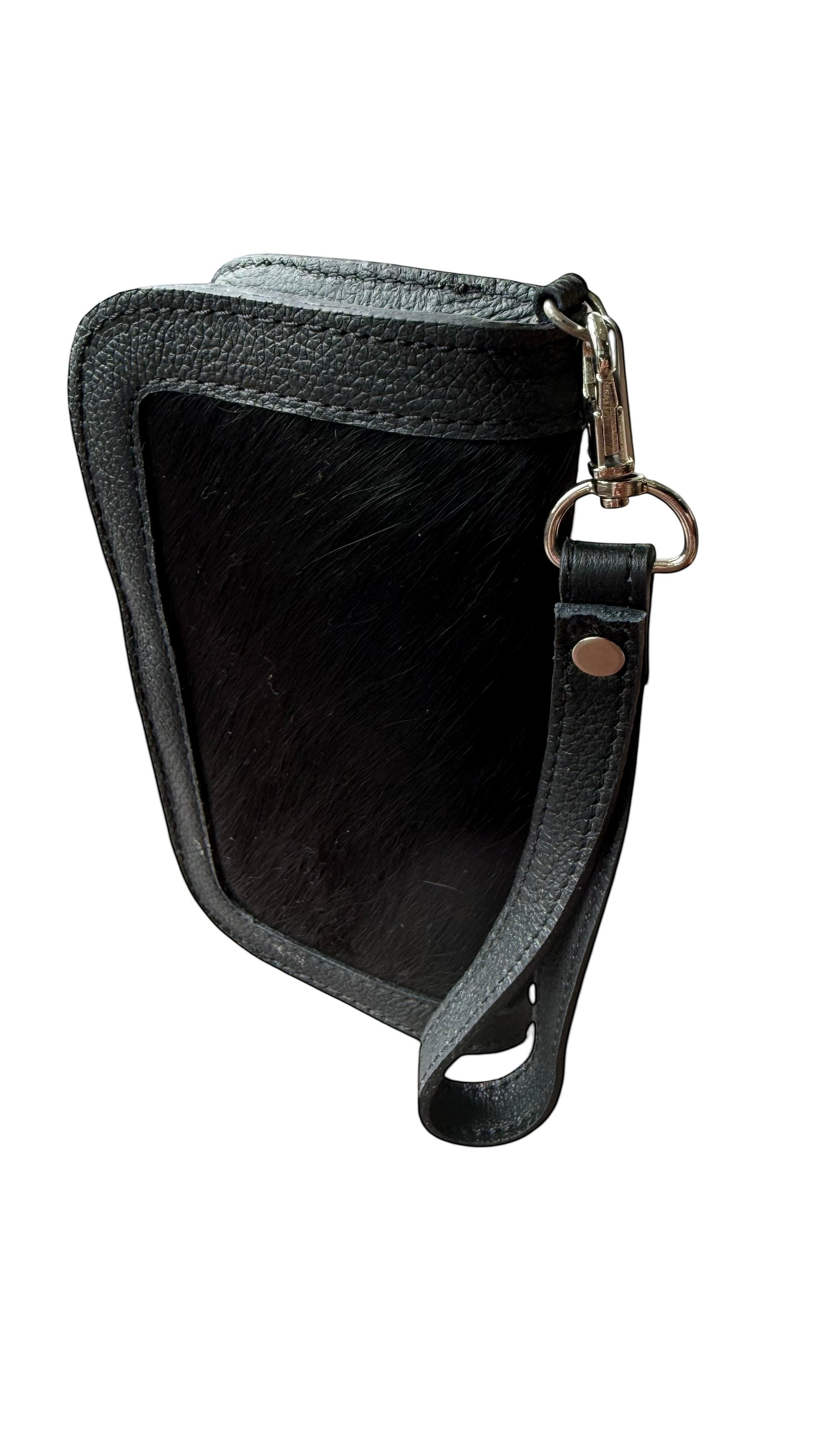 David Dangelo Caldwell black leather and hair-on hide wristlet clutch with silver hardware and wrist strap.