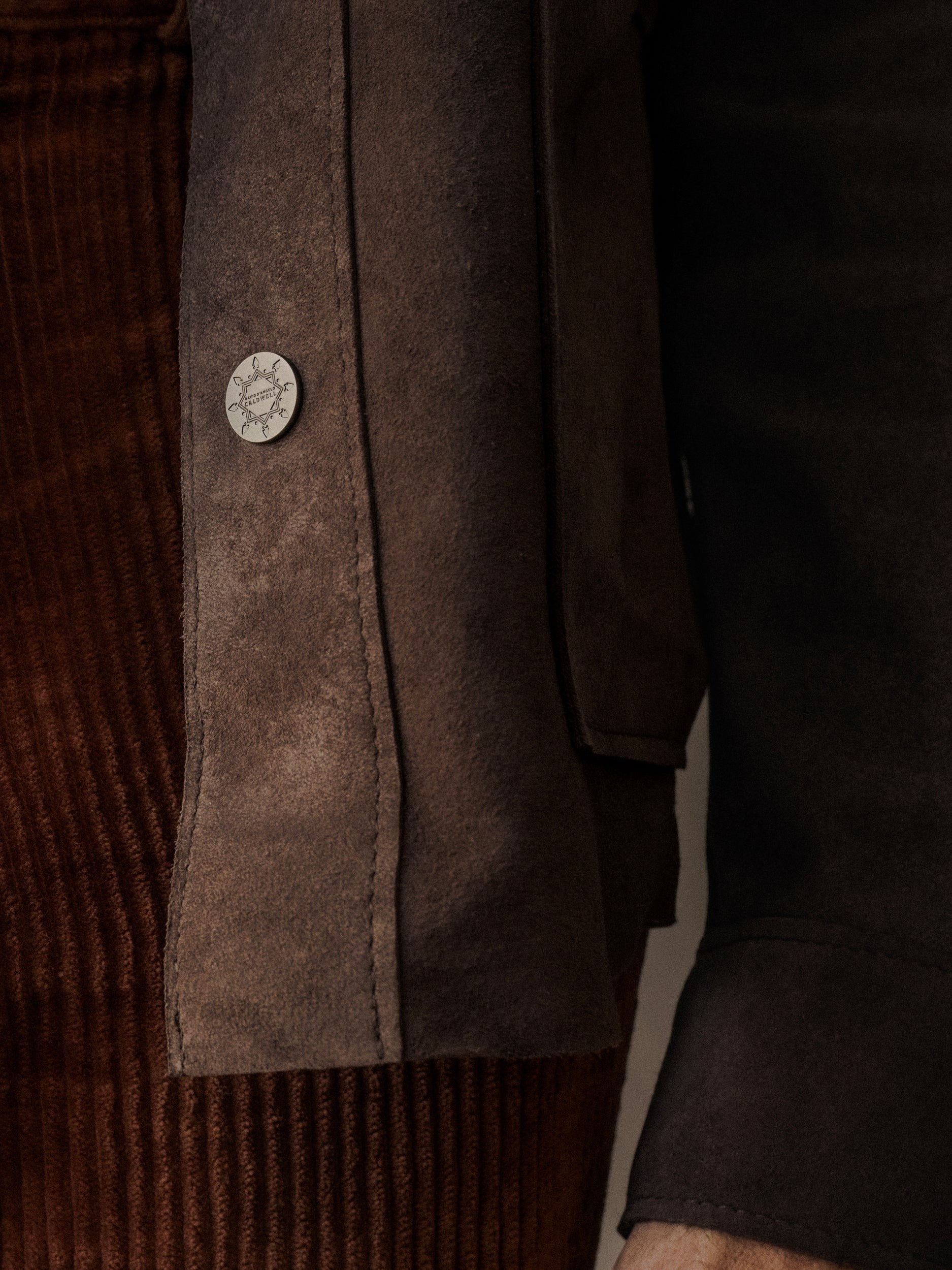 David Dangelo Caldwell brown suede jacket with custom hardware and exposed stitching. Classic fit with patch pockets.