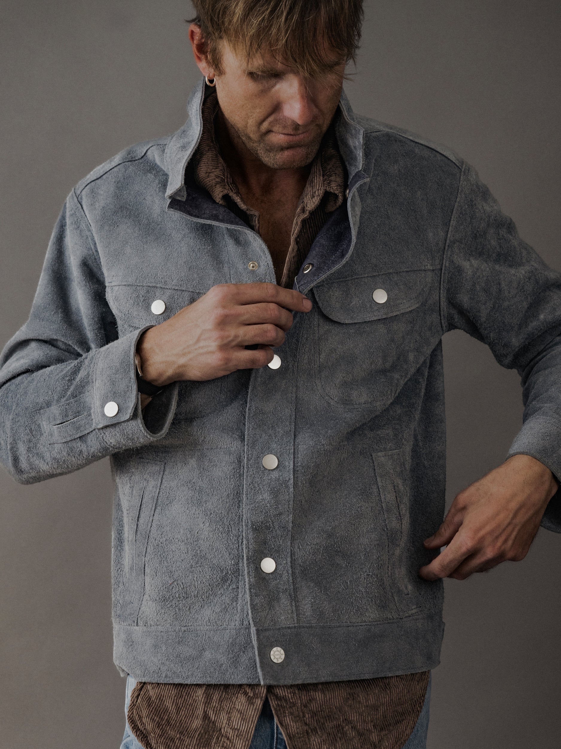 David Dangelo Caldwell grey suede trucker jacket with exposed seams and silver snap buttons, reversible design.