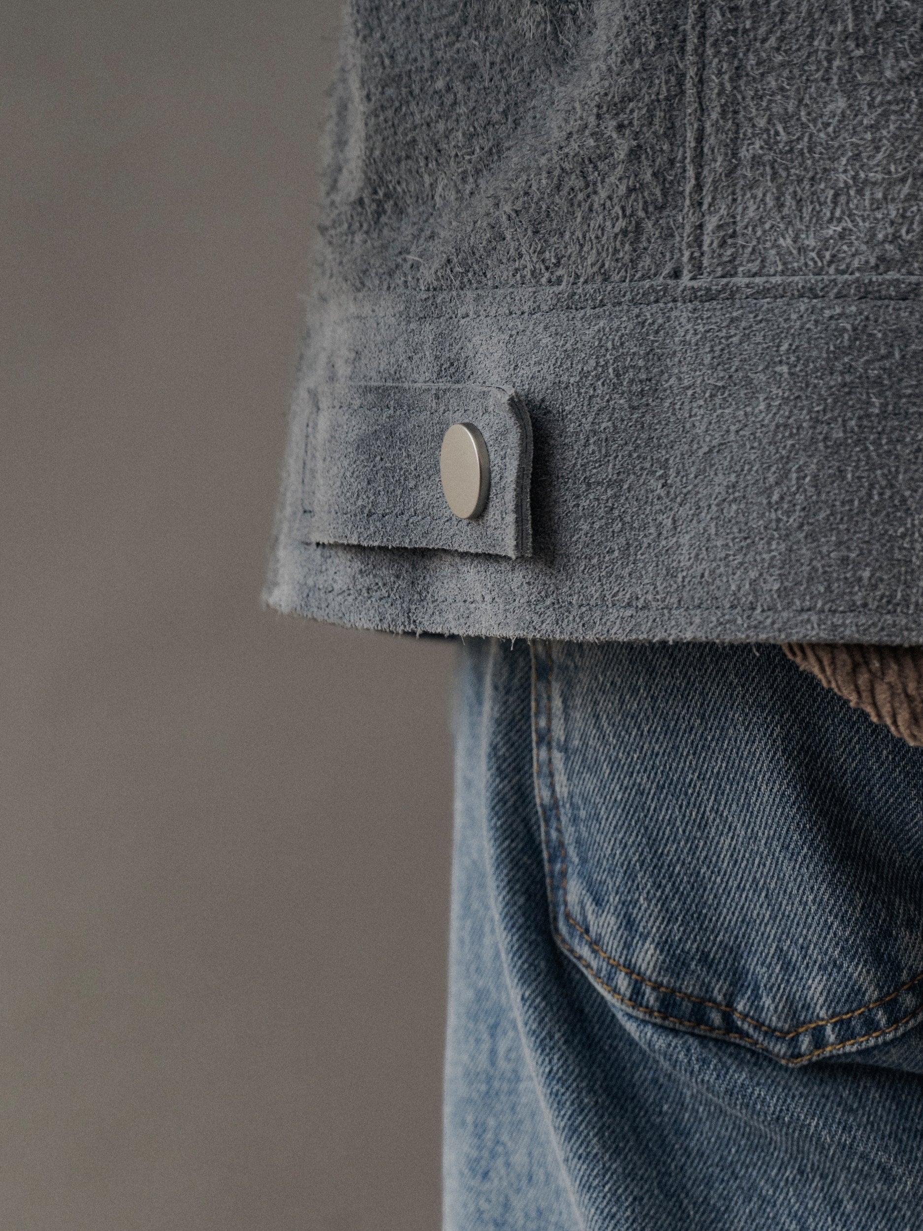 David Dangelo Caldwell grey suede trucker jacket with exposed seams and silver button detail.