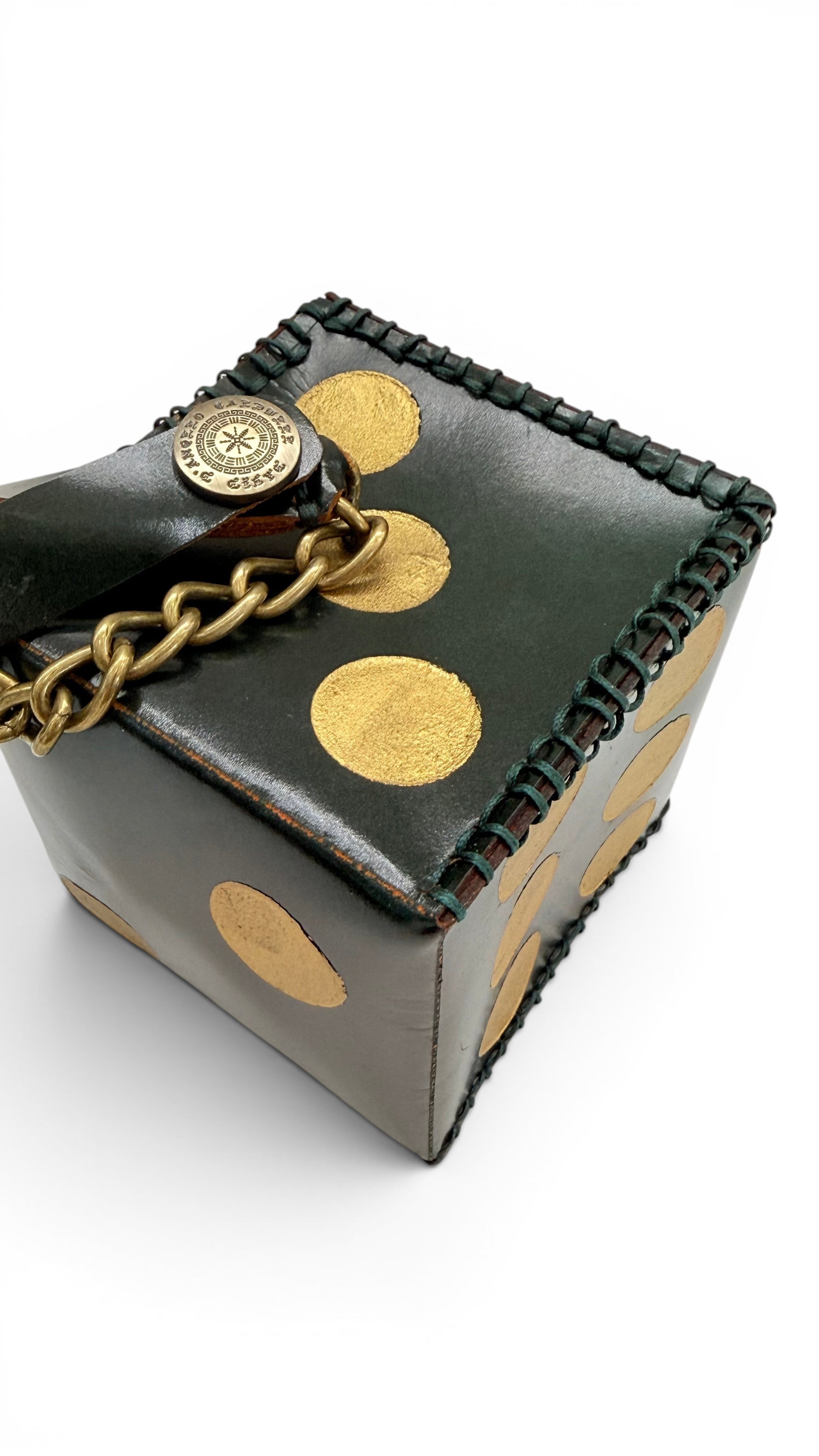 David Dangelo Caldwell dark green leather dice charm with gold dots and brass chain, hand-stitched detail.