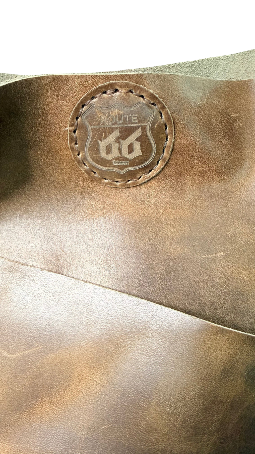 David Dangelo Caldwell brown leather tote bag with fringe detail and Route 66 logo patch.
