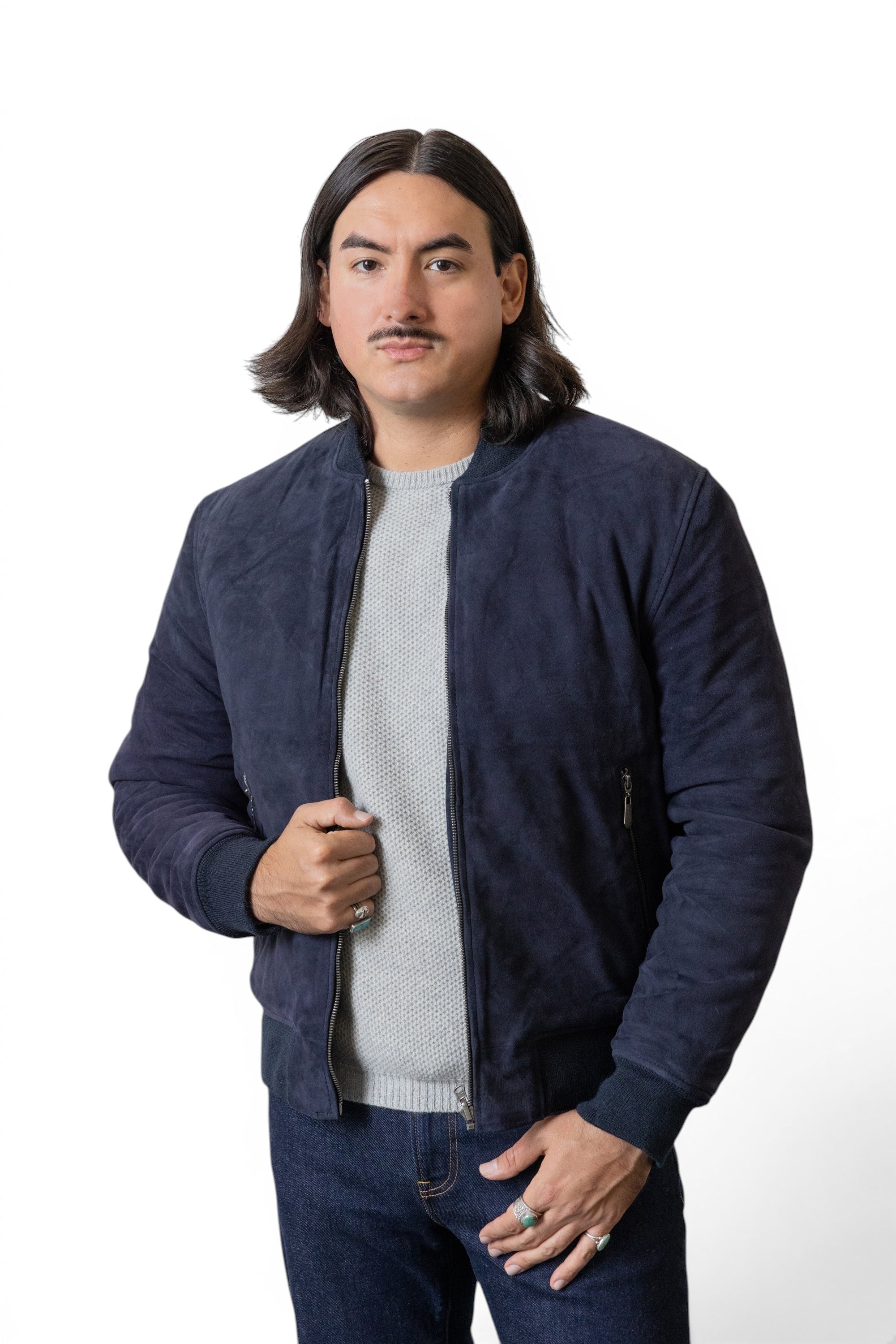 David Dangelo Caldwell navy blue suede bomber jacket with puffer lining, worn by a man with dark hair and a mustache.