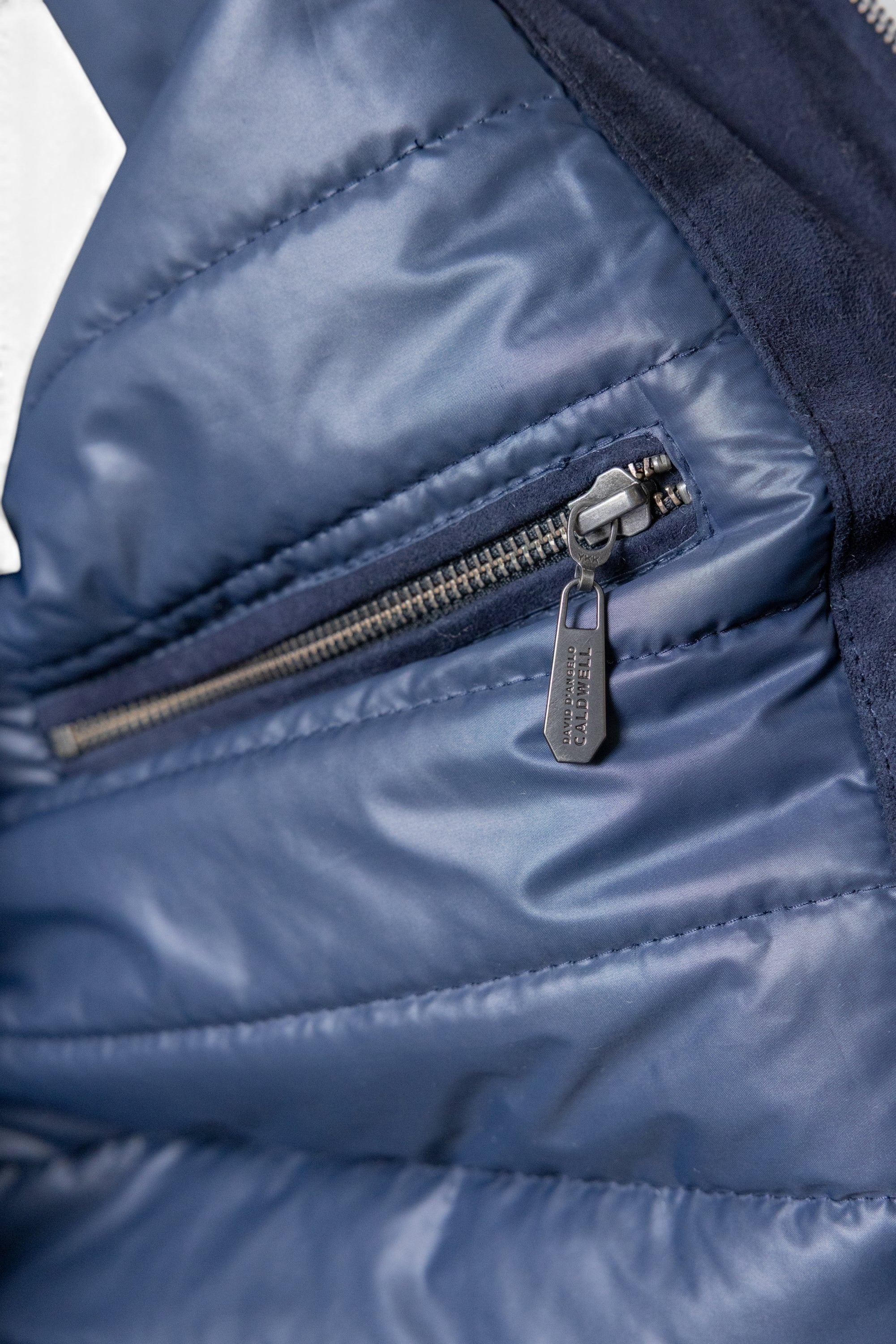 David Dangelo Caldwell navy blue reversible bomber jacket with puffer lining and suede exterior, featuring a zip pocket.