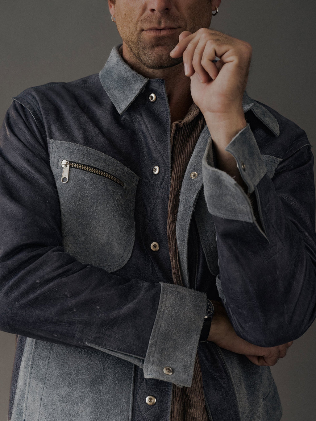 David Dangelo Caldwell reversible trucker jacket in dark blue suede with exposed seams and a zippered chest pocket.