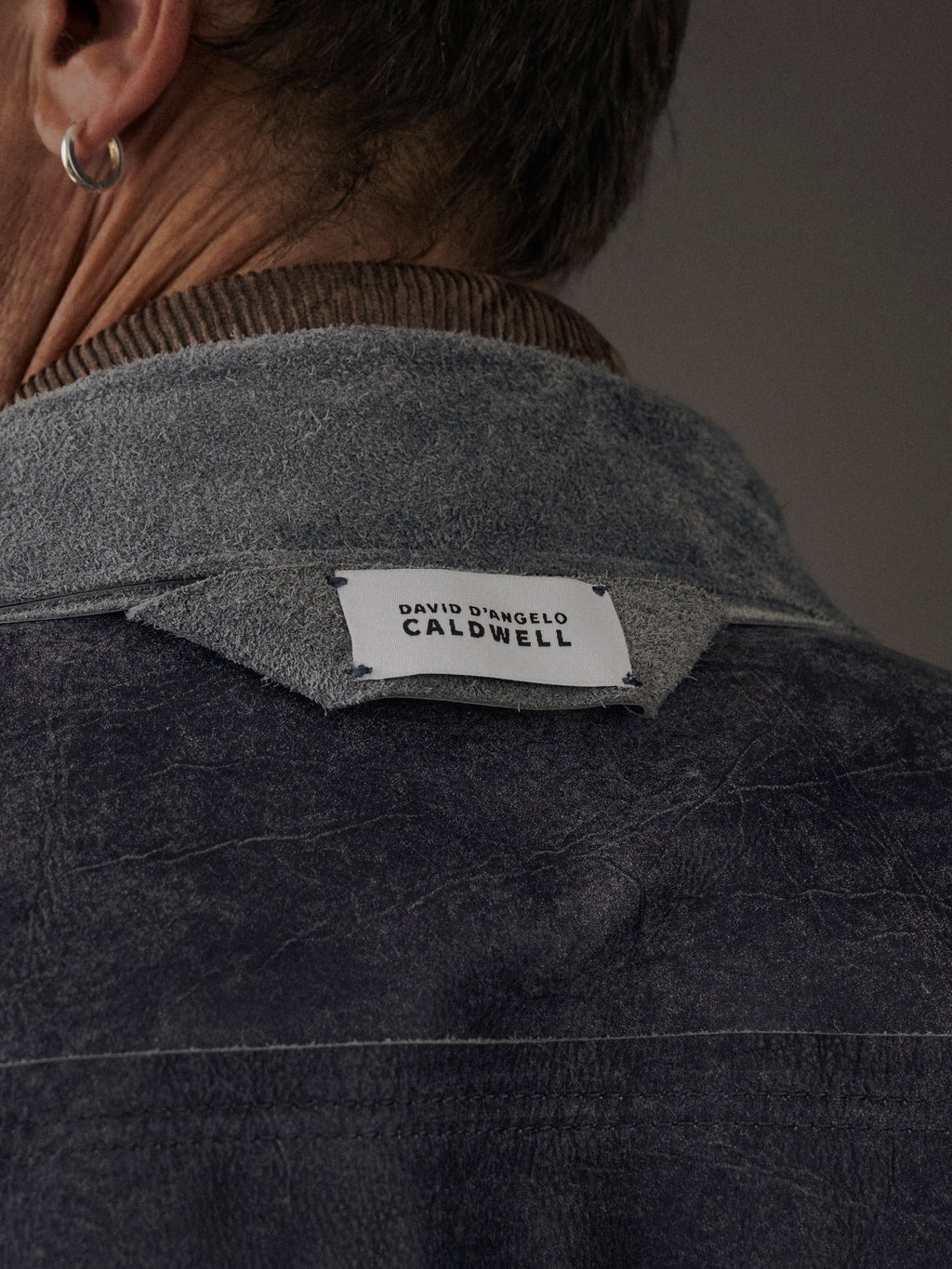 David Dangelo Caldwell reversible trucker jacket in dark grey suede with exposed seams and proprietary hardware.