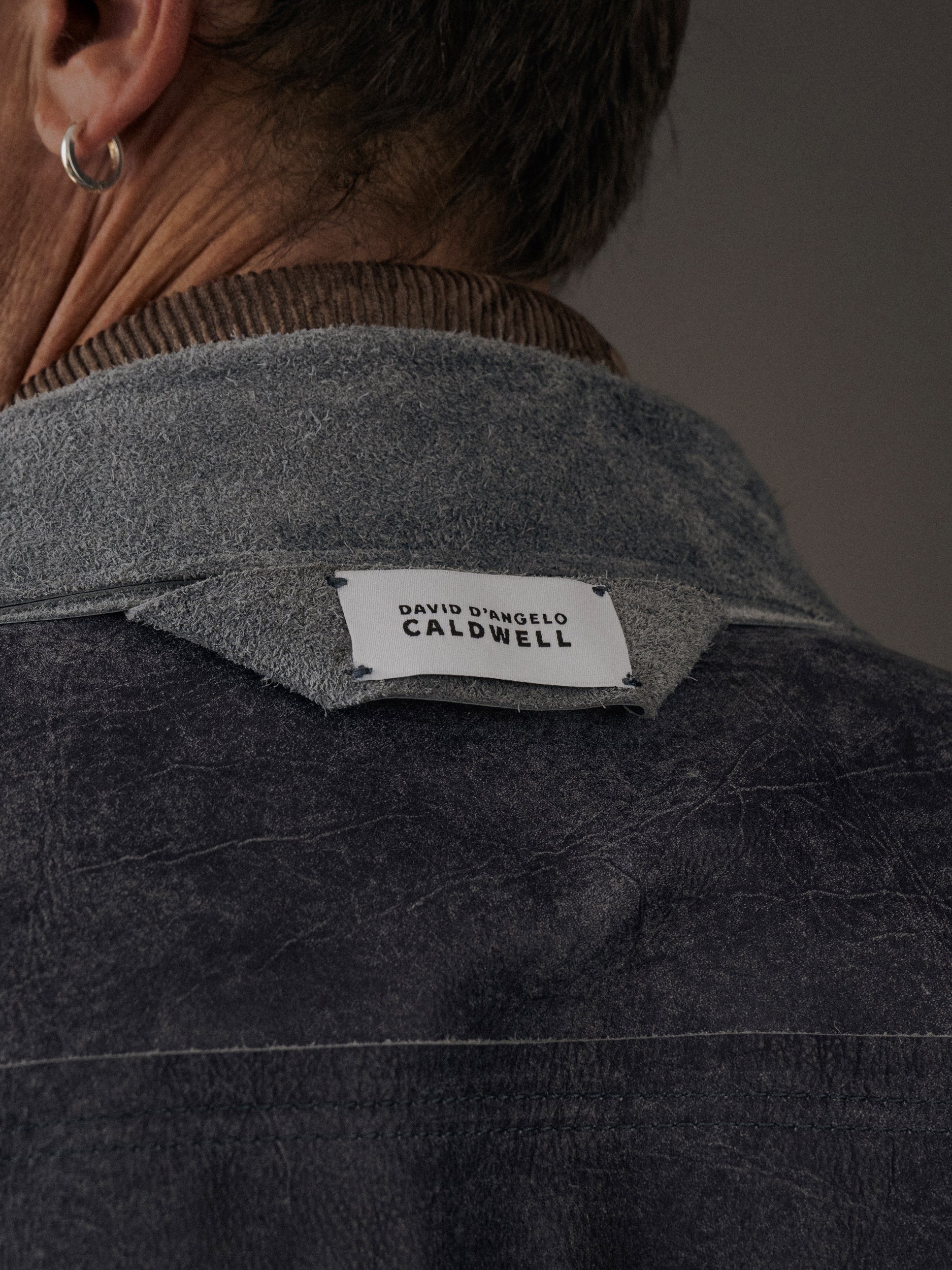 David Dangelo Caldwell reversible trucker jacket in dark grey suede with exposed seams and proprietary hardware.