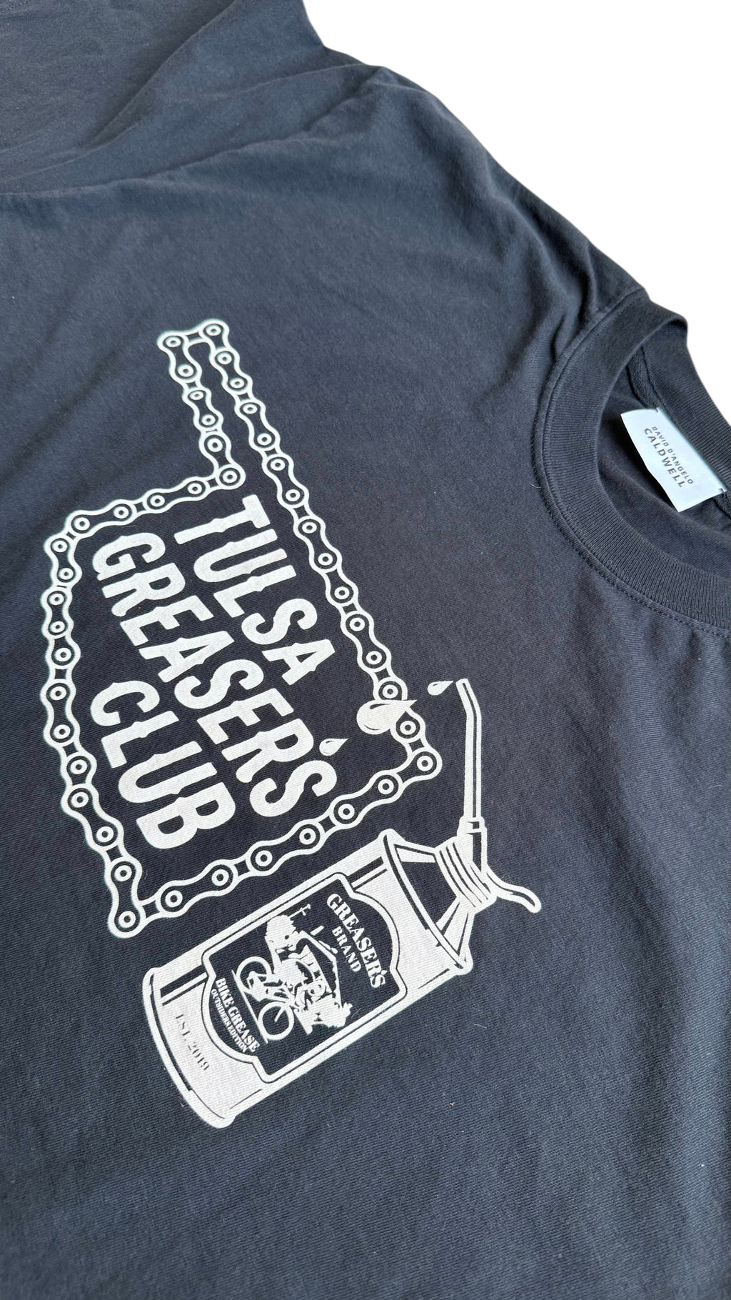 David Dangelo Caldwell dark grey 100% cotton Tulsa Greaser's Club t-shirt with chain graphic and oil can.